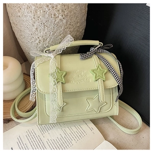 Detail of light green star embossed square handbag with lace and checkered bow accents