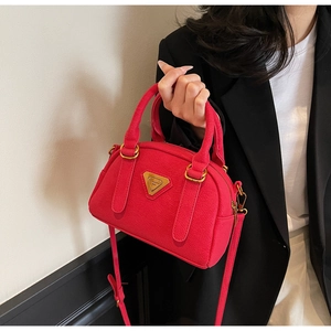 Detail of fuchsia litchi pattern leather Boston bag with triangle logo and gold zipper