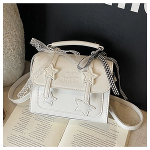 Detail of white star square bag with lace ribbons and black-white checkered bow accent