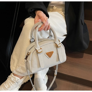 Detail of lychee pattern leather Boston bag with metal logo and gold hardware