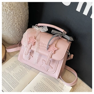 Detail of pink PU leather handbag with star accents, lace ribbons and checkered bow