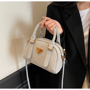 Detail of light gray lychee grain leather Boston bag with vintage gold metal logo plate