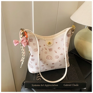 Detalle del bolso de hombro crema con estampados de perros lindos y lazo rosa decorativo