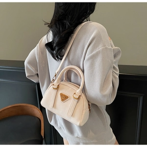 Detailed side view of a beige Boston bag with golden triangle logo and shoulder strap