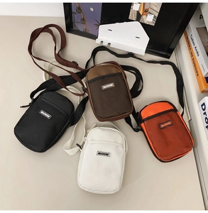 Detailed overhead view of four nylon mini crossbody bags with mesh pockets and straps