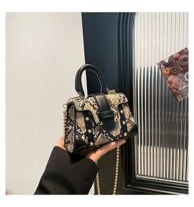 Detailaufnahme der Handtasche mit Schlangenmuster Goldnieten und Kettenriemen
