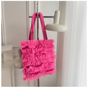 Détail des couches de volants roses et de la texture plissée en mesh d'un sac cabas