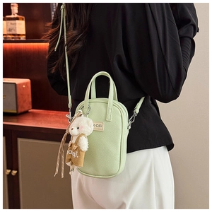 Détail du mini sac vert menthe à motif litchi avec breloque ours et étiquette K.CiCi