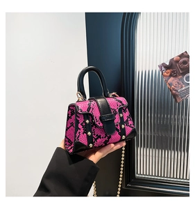 Detailansicht der Mini-Tasche mit rosa-schwarzem Schlangenmuster und Goldnieten