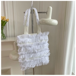Gros plan détaillé montrant les volants en tulle blanc superposés sur le sac fourre-tout