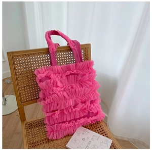 Vue détaillée du sac cabas en tulle rose avec couches plissées sur une chaise en bois rétro