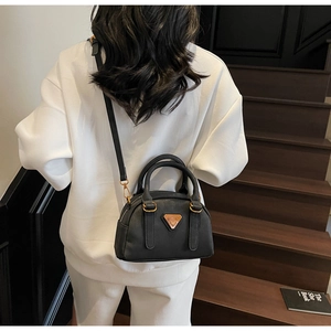 Classic black leather Boston bag with gold hardware and logo plate shown on model