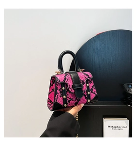 Details der rosa Mini-Tasche mit Schlangenmuster, Goldnieten und eleganter Kette