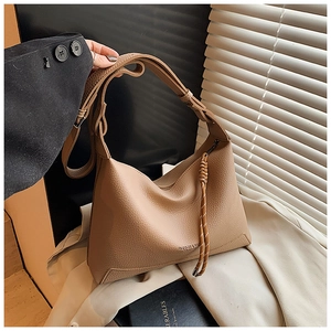 Detailed close-up of khaki lychee grain leather tote bag with wide strap and fashion logo