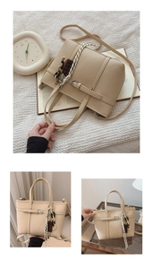 Detail of beige lychee textured bucket bag with striped scarf and chocolate charm