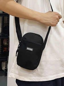 Minimalist black nylon mini crossbody bag with adjustable strap and front logo patch
