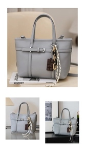 Macro detail of grey litchi texture bucket bag with metal buckle and decorative charms