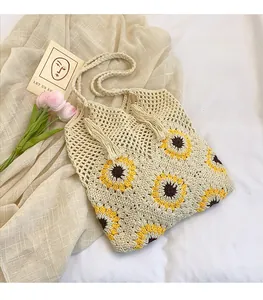 Vue détaillée d'un cabas tissé main avec motif tournesol et pendentifs à glands