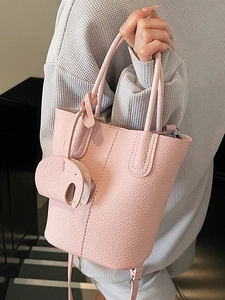 Borsa a secchiello in pelle rosa con grana litchi, ciondolo elefante e tracolla