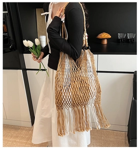 Detail view of the boho woven tote bag with long fringe tassels and mesh cutout design