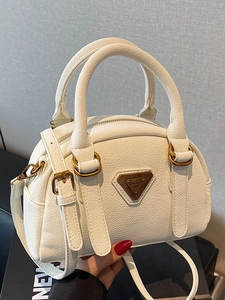 Minimalist white Boston handbag in lychee leather with vintage bronze hardware and crossbody strap