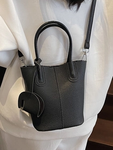 Borsa a secchiello nera a grana di litchi con ciondolo a elefante e tracolla