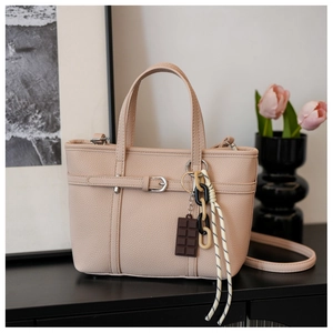 Detail of lychee pattern leather bucket bag in beige with chocolate charm and chain