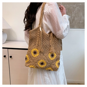 Détail du sac cabas en paille tissé main avec motif tournesol et glands décoratifs
