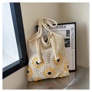 Détail du sac cabas au crochet avec tournesols, pompons à franges et anses tressées