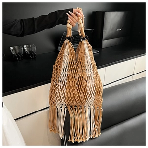 Detail of hand-woven tote bag featuring wooden bead handles and long fringe tassels