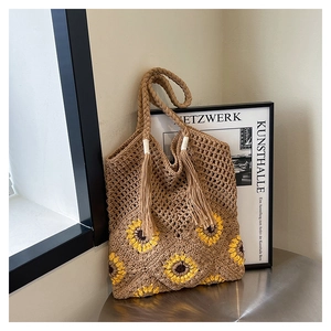 Détail du sac cabas bohème en tricot avec motifs tournesols et poignée à glands