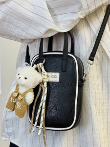 Sac bandoulière noir texture litchi avec liseré blanc et breloque ours en peluche