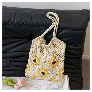 Détail d'un sac cabas crocheté à la main avec motifs de tournesols jaunes et texture en maille