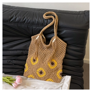 Détail du cabas bohème tissé à la main avec motifs de tournesol, pompons et anses tressées