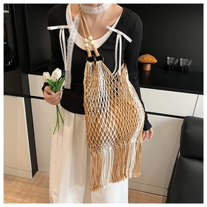 Detail of hand-woven tote bag with fringe tassels and wooden bead strap accents