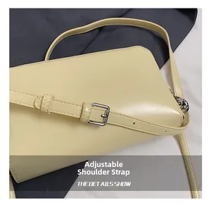 Detail showing the adjustable slim leather shoulder strap with silver buckle and stitching