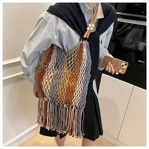 Close-up of bohemian woven tote bag with fringe tassels and wooden bead strap