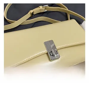 Detail of silver rectangular metal twist lock on a light yellow oil wax leather handbag