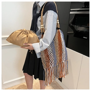 Detail view of woven hollow tote bag with colorful tassels and wood bead strap