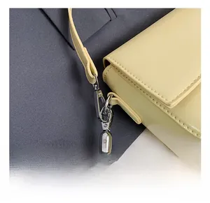 Close-up of silver metal hook and premium leather strap on cream crossbody bag