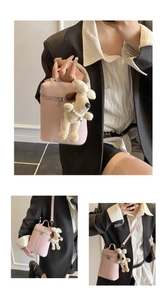 Detailed view of pink lychee textured bucket bag featuring a cute plush dog charm