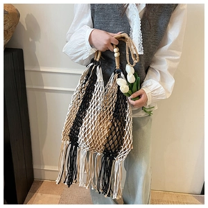 Detail of hand-woven hollow tote bag with contrast stitching and long fringes