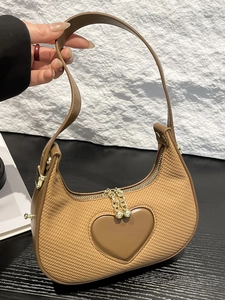Brown crescent underarm bag with heart detail and textured woven finish for women