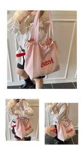 Detailed view of pink canvas tote bag with red beach print and drawstring closure