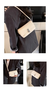 Detail view of cream white square crossbody bag with silver metallic stripe lock and strap