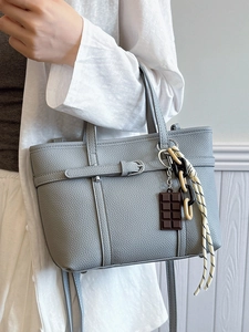 Chic grey-blue lychee pattern bucket bag with decorative charms and crossbody strap