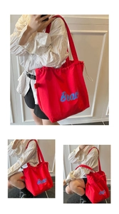 Detail of red drawstring tote bag with Beach print showing fabric texture and strap