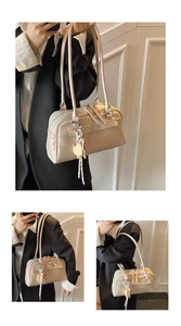 Close-up of beige Boston handbag with pearlescent finish and heart-shaped charm detail