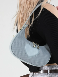 Minimalist light blue heart shoulder bag with corduroy texture and leather trim on a model