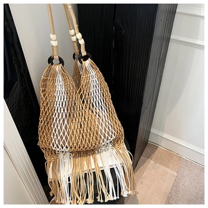 Detail of bohemian woven tote bag with resin rings, wooden beads and long fringe tassels
